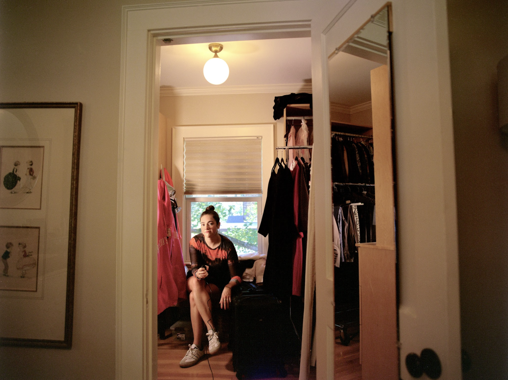 Girl sitting on a bed between door frames